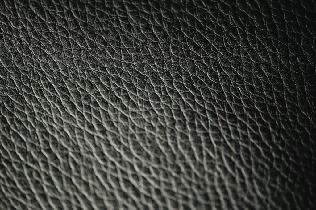 Macro photograph showcasing the intricate texture and pattern of black leather.